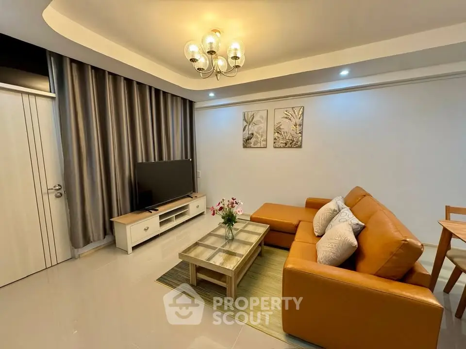 Modern living room with stylish decor, leather sofa, and elegant lighting in a cozy apartment.