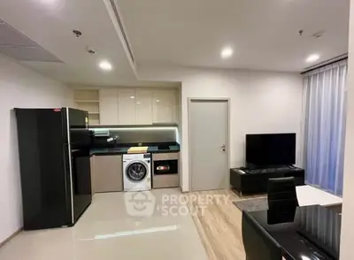 Modern open-layout kitchen and living area with sleek appliances and stylish decor.