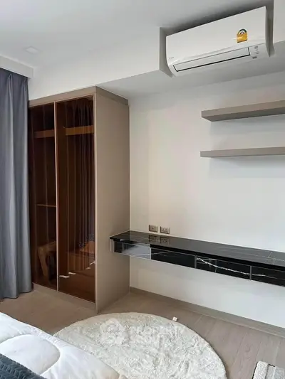 Modern bedroom with built-in wardrobe and sleek air conditioning unit