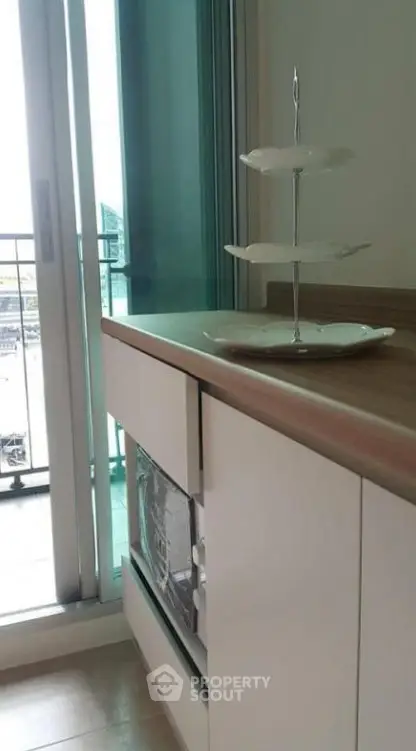 Modern kitchen with sleek cabinetry and balcony access, perfect for urban living.