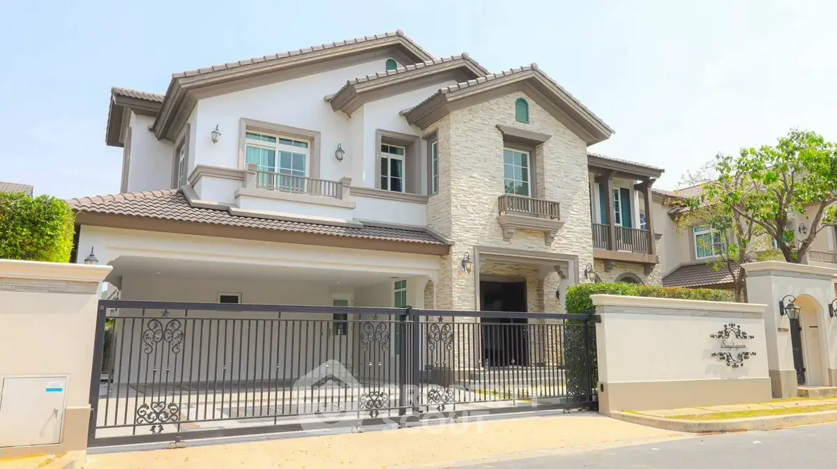Luxurious two-story house with elegant facade and gated entrance in a serene neighborhood.