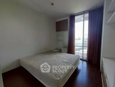 Spacious bedroom with large window and balcony access in modern apartment