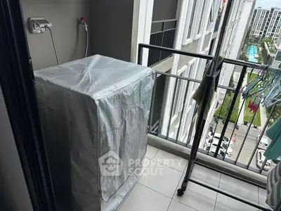 Compact balcony with washing machine and city view, ideal for urban living.