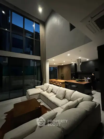 Luxurious modern living room with high ceilings and open kitchen layout