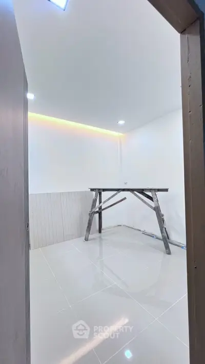 Spacious unfurnished room with tiled flooring and modern lighting, ideal for customization.