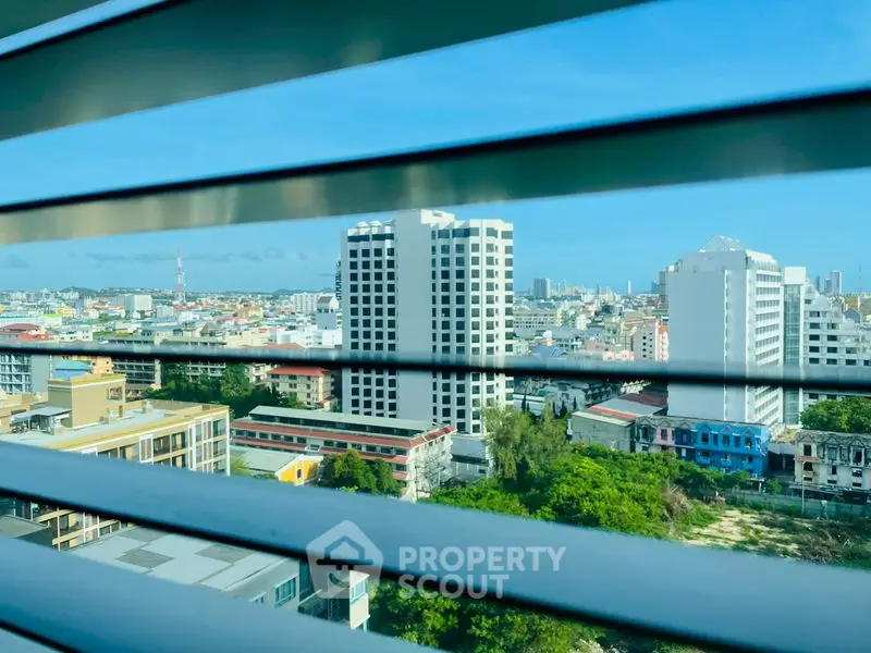 Stunning cityscape view from high-rise building window with blue sky.