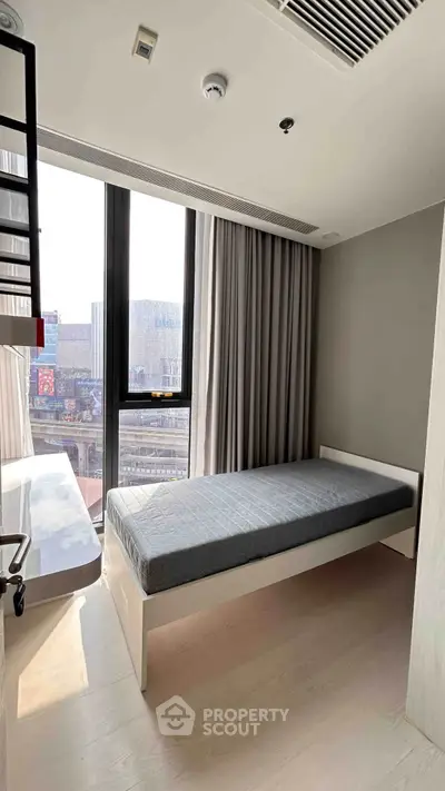 Modern minimalist bedroom with large window and single bed in urban apartment