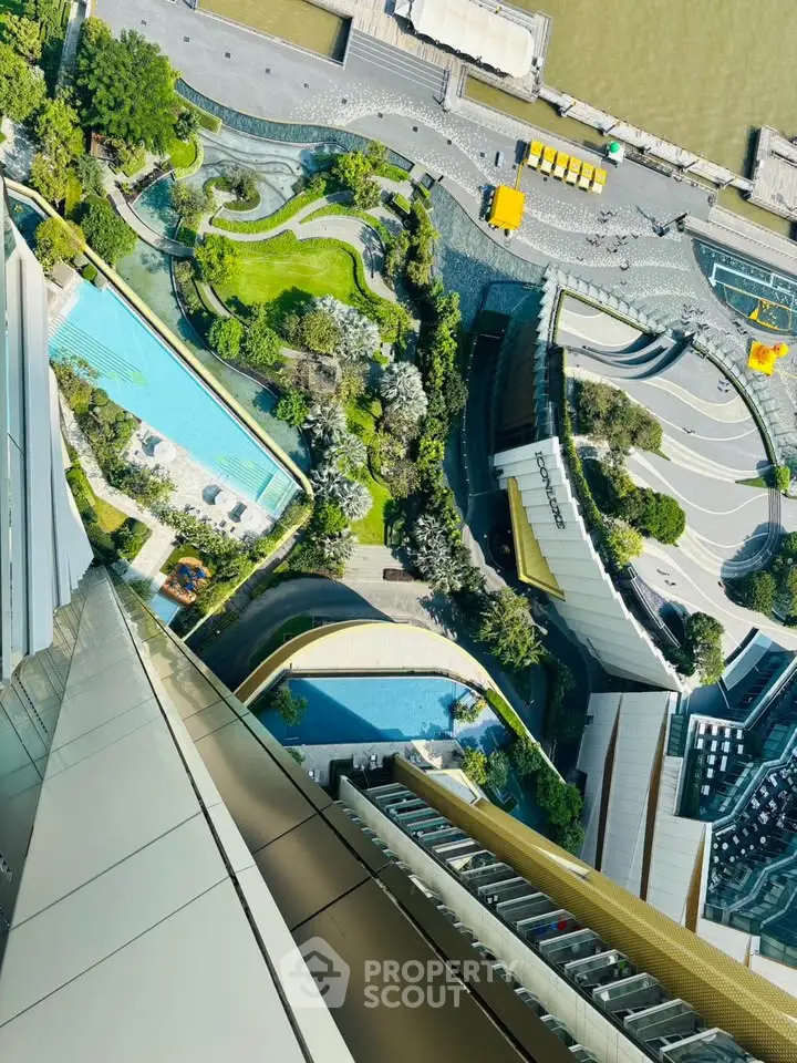 Stunning aerial view of modern building with rooftop pool and lush garden, overlooking vibrant urban landscape.