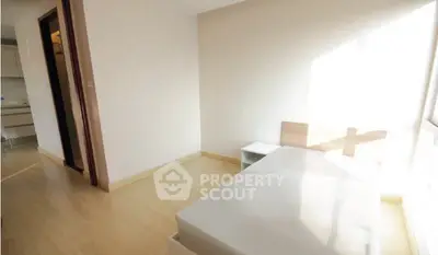 Bright minimalist bedroom with wooden flooring and natural light