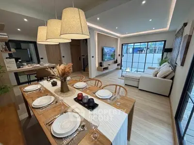 Modern open-plan living and dining area with stylish decor and natural lighting.