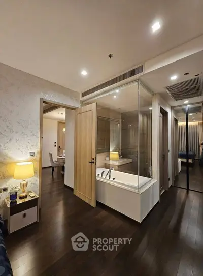 Modern apartment interior with glass-enclosed bathtub and stylish decor