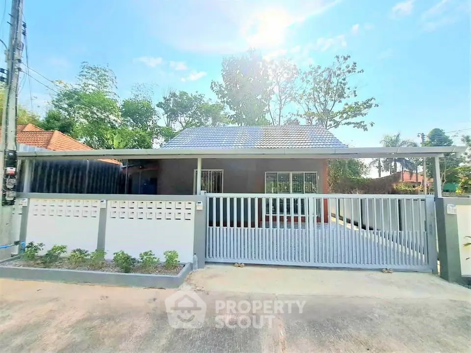 Charming single-story house with gated entrance and spacious driveway in a serene neighborhood.