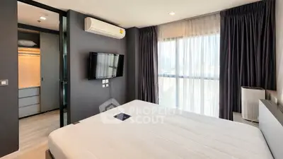 Modern bedroom with large window, wall-mounted TV, and air conditioning in a stylish apartment.