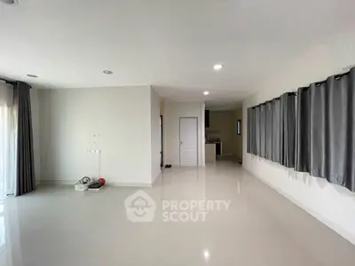 Spacious unfurnished living room with large windows and sleek tile flooring