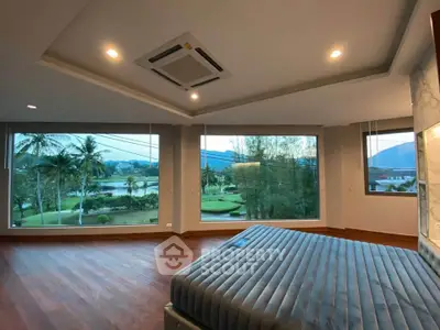 Luxurious bedroom with panoramic golf course view and modern design.