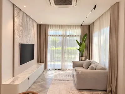 Elegant living room with large windows, modern decor, and cozy seating area.