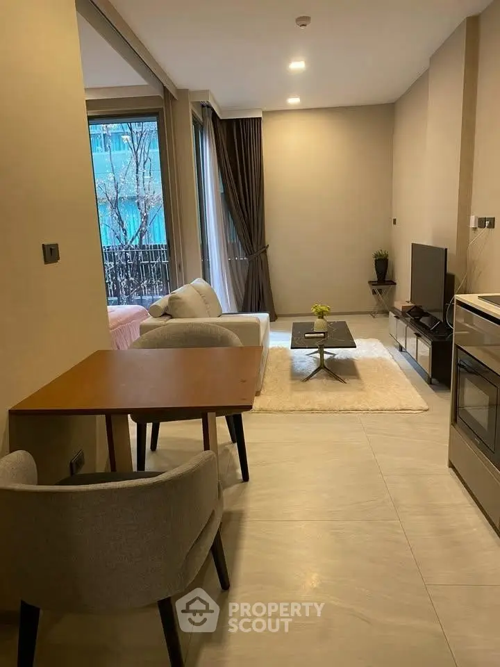 Modern living room with cozy seating and large windows in a stylish apartment.