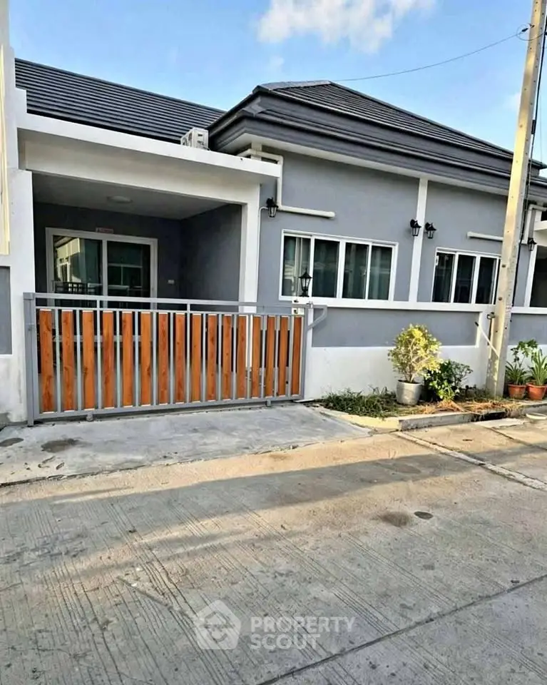 Charming single-story home with modern facade and gated driveway in a serene neighborhood.