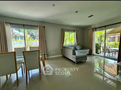 Spacious living room with modern furniture and garden view, perfect for family gatherings.