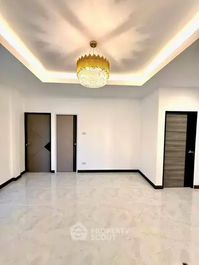 Spacious modern living room with elegant chandelier and sleek doors