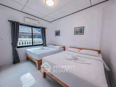 Spacious bedroom with two beds and natural light, perfect for comfort and relaxation.