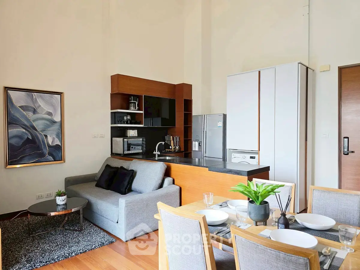 Modern living room with open kitchen, stylish decor, and dining area
