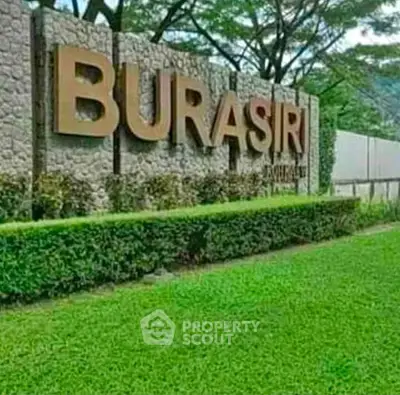 Elegant entrance sign of Burasiri with lush green landscaping.