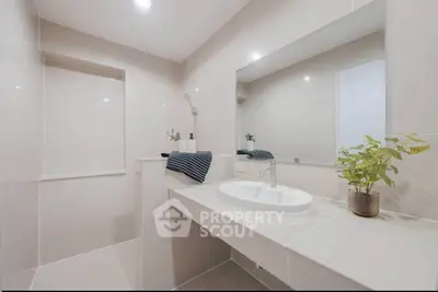 Modern bathroom with sleek design and elegant fixtures, featuring a spacious vanity and stylish decor.