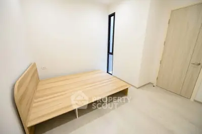 Minimalist bedroom with wooden bed frame and natural light