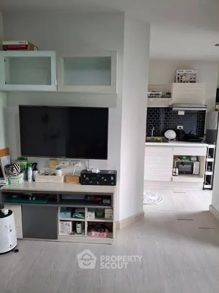 Modern living room with open kitchen layout and sleek appliances