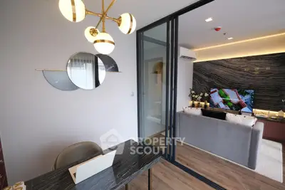 Modern living room with stylish decor and open layout, featuring a sleek black marble table and elegant lighting.