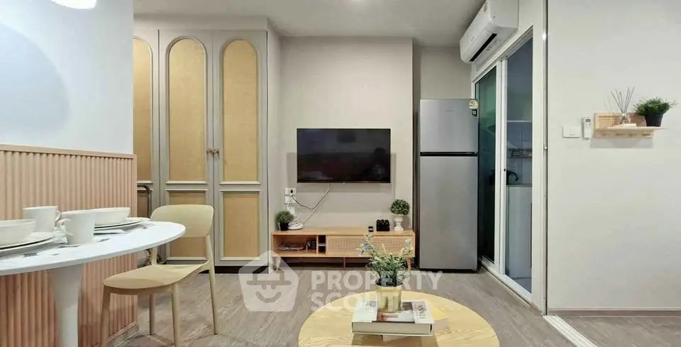 Modern living room with stylish decor, wall-mounted TV, and sleek kitchen area in open layout apartment.