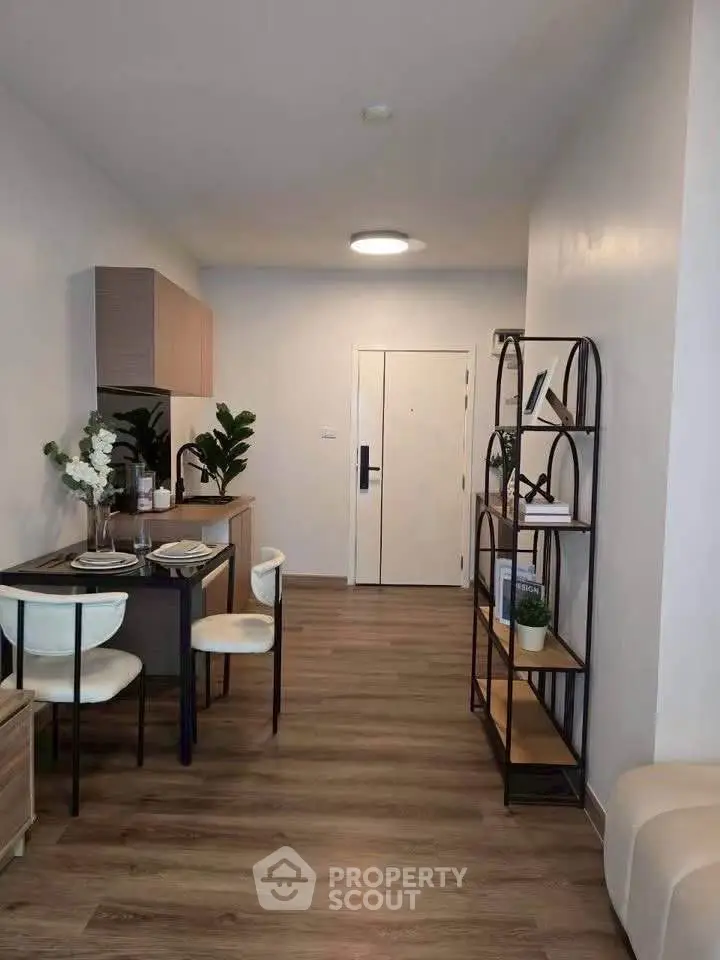 Modern apartment interior with dining area and stylish shelving, featuring elegant decor and wooden flooring.