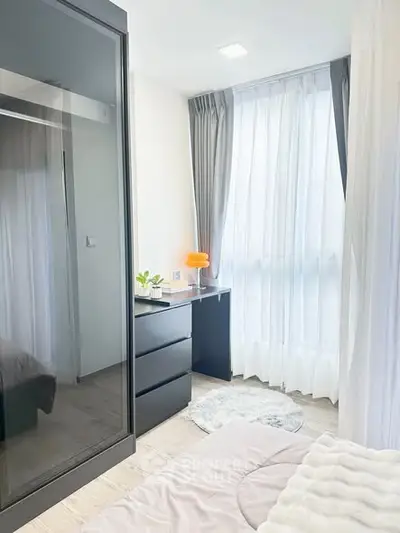 Bright and modern bedroom with floor-to-ceiling windows and sleek furnishings.