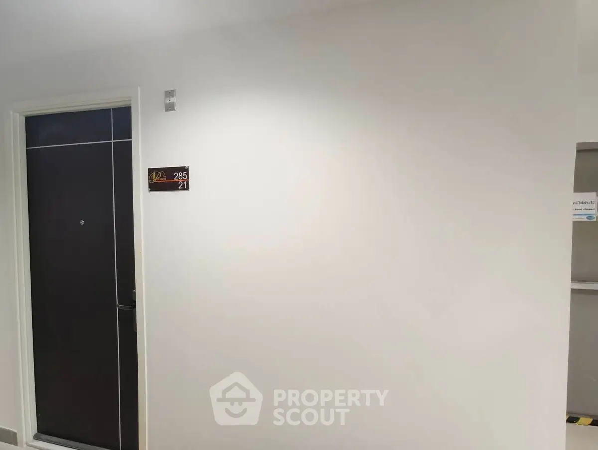Modern apartment entrance with sleek door and room number signage.