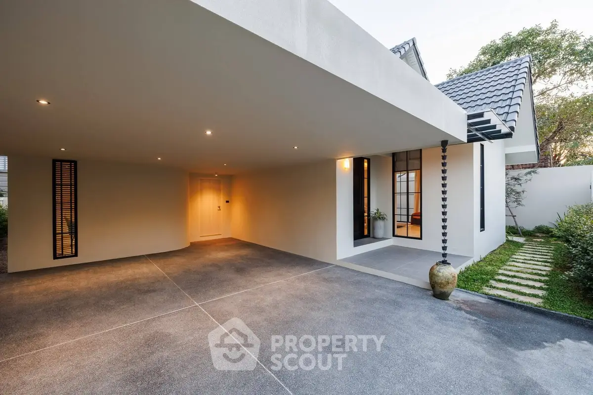 Modern minimalist home exterior with covered driveway and sleek architectural design.