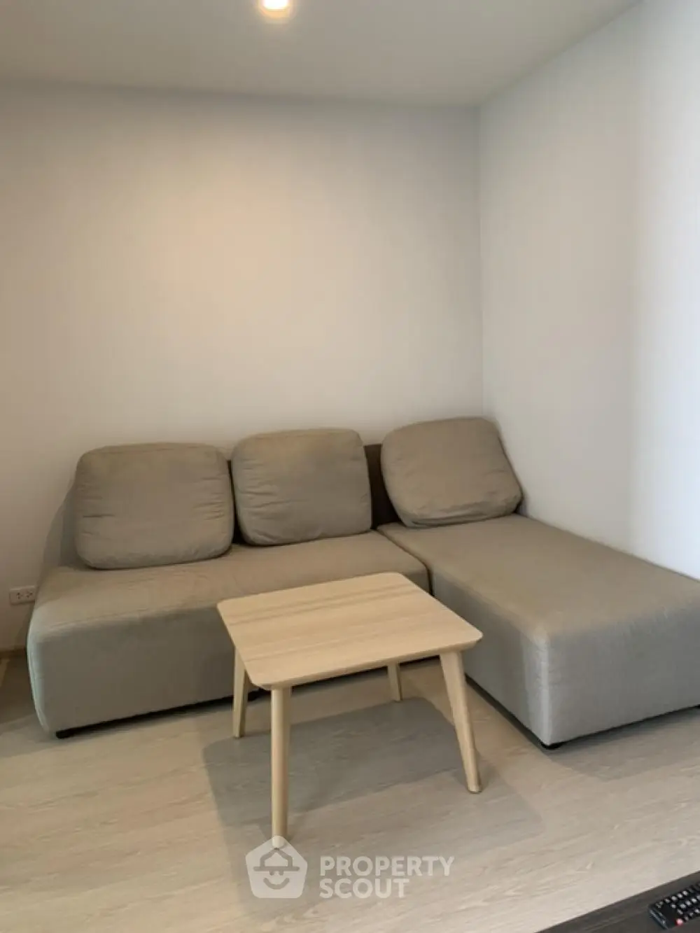 Cozy modern living room with stylish beige sofa and wooden coffee table.