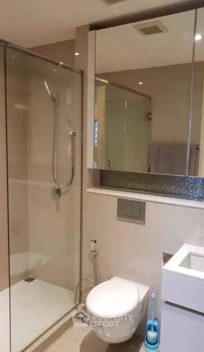 Modern bathroom with glass shower and sleek fixtures in a contemporary home.