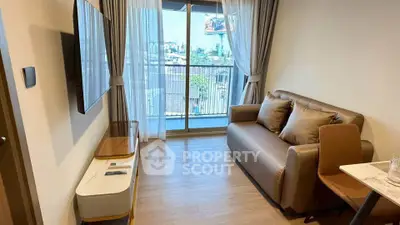 Modern living room with balcony view, featuring sleek furniture and natural light.
