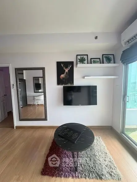 Modern living room with stylish decor and wall-mounted TV, featuring large mirror and natural light.