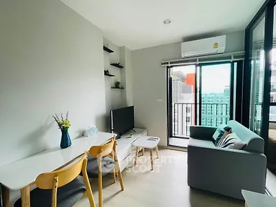 Modern living room with balcony view, stylish furniture, and natural light in a contemporary apartment.