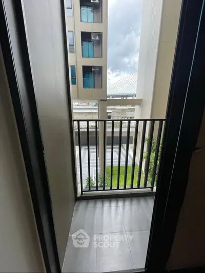 Modern apartment balcony with city view and sleek railing design.