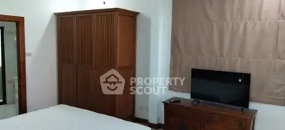 Cozy bedroom with wooden furniture and modern TV setup