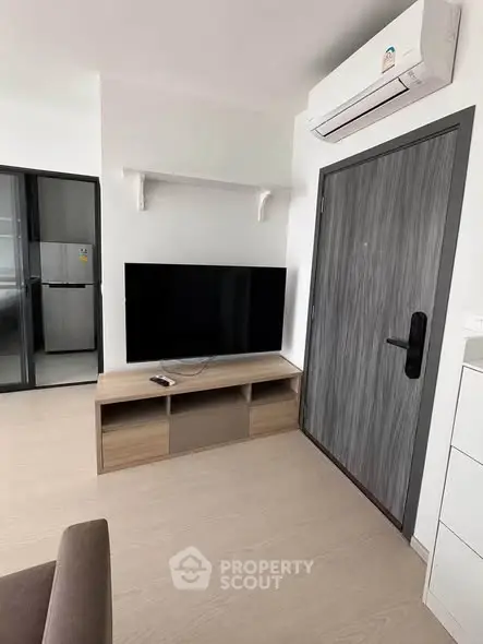 Modern living room with sleek TV setup and air conditioning in a stylish apartment.
