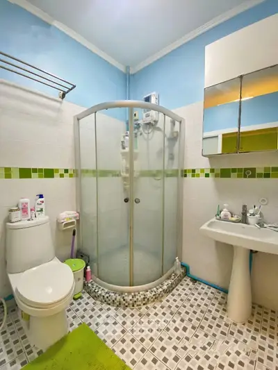 Charming bathroom with modern shower and colorful tiles, perfect for a cozy home.