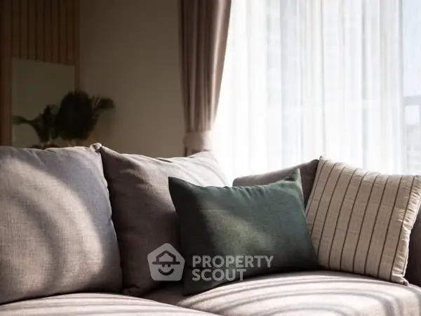 Cozy living room with elegant sofa and soft natural lighting.