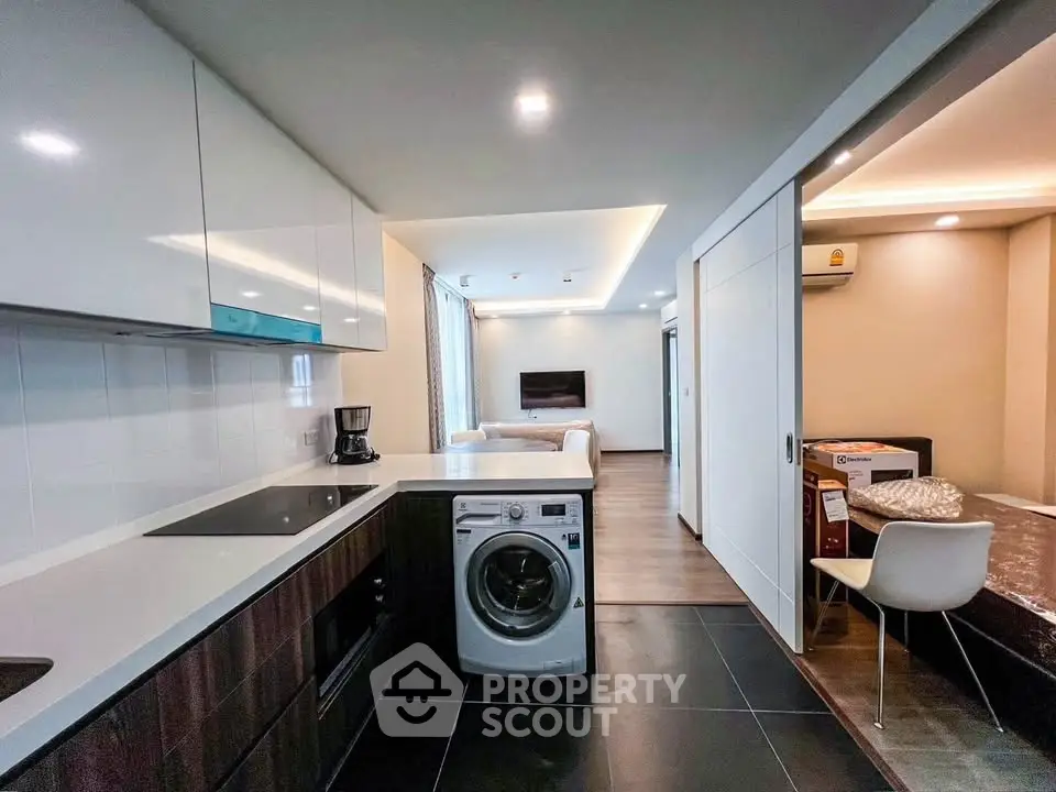 Modern open kitchen with washing machine and sleek living area