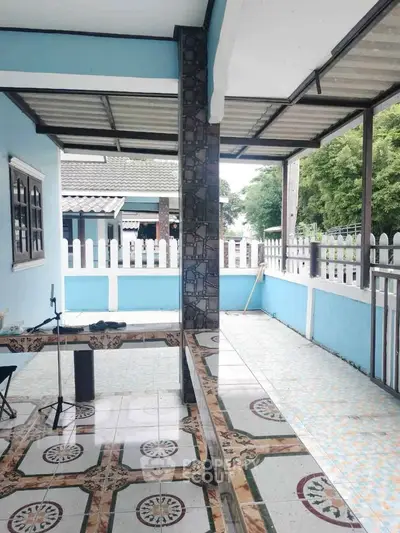 Charming covered patio with decorative tiles and blue accents, perfect for outdoor relaxation.