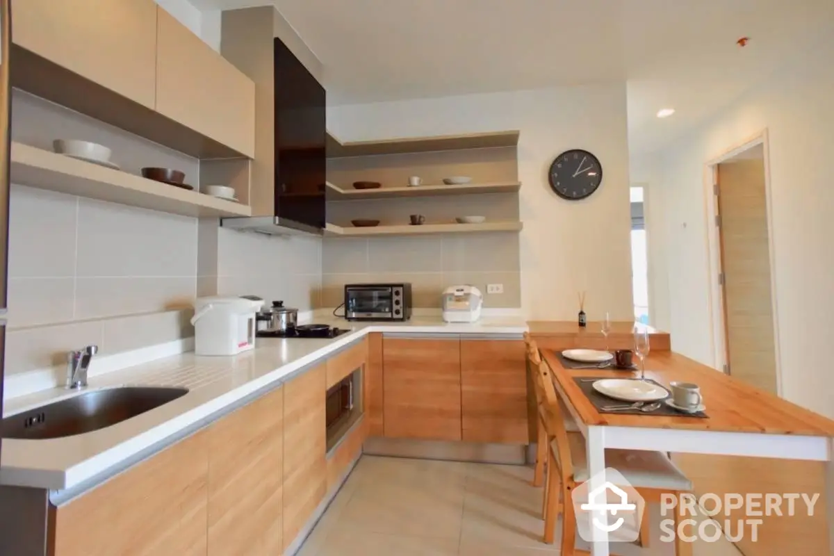 Modern kitchen with wooden cabinets and open shelving in a cozy apartment