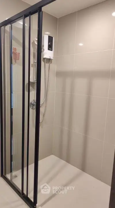 Modern bathroom with sleek glass shower enclosure and tiled walls